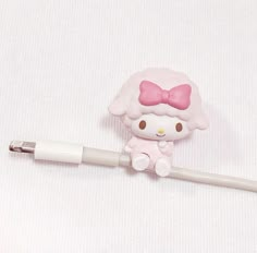 a hello kitty cell phone charger plugged in to a white cord with a pink bow on it