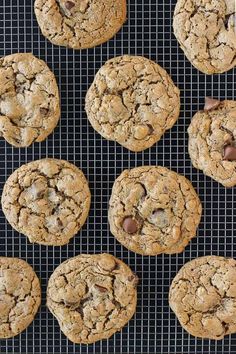 chocolate chip cookies on a cooling rack with one cookie broken in half and the other uncooked