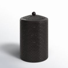 a black canister sitting on top of a white surface