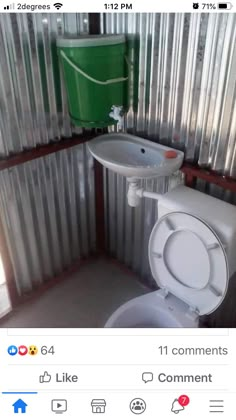 a white toilet sitting next to a sink in a bathroom under a green trash can