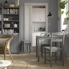 a dining room table and chairs in front of a bookshelf