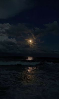 the full moon shines brightly in the dark night sky over the ocean with waves