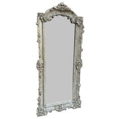 an ornate white framed mirror against a white wall