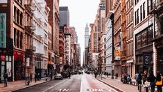 an empty city street with people walking on the sidewalk