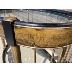 an antique brass and glass coffee table with wheels on it's sides, from the early 20th century