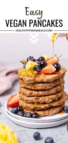 a stack of vegan pancakes with berries and syrup being drizzled on top