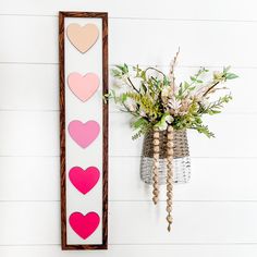 a vase with flowers sitting next to a wall decoration