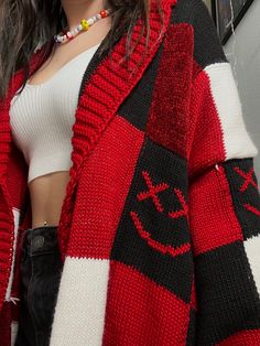 a woman wearing a red and black striped cardigan with an anchor symbol on it