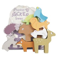 an assortment of wooden toy animals sitting in front of a bag with the words forest stack tower written on it