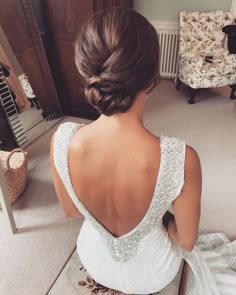 a woman sitting on the floor in front of a mirror wearing a wedding dress and gloves