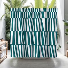 a green and white striped shower curtain next to a potted plant in a bathroom