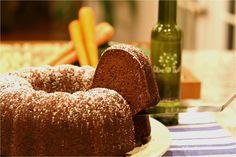 a bundt cake sitting on top of a white plate next to a green bottle