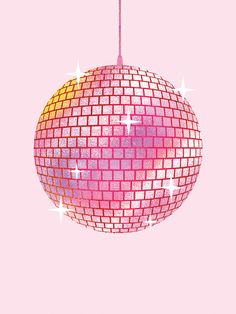 a disco ball ornament hanging from a pink wall with stars on it's side