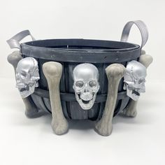 there are three skeleton heads in the basket with two bones sticking out of it's sides