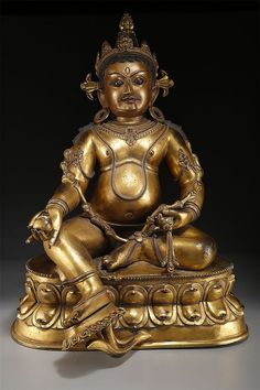 a golden buddha statue sitting on top of a table