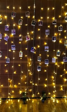 string lights are hanging from the wall with pictures on them and photos pinned to it