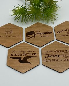 six wooden coasters with different quotes on them and a potted plant in the background