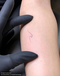 a woman's arm with a small tattoo on it