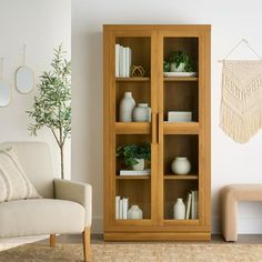 a living room filled with furniture and a white chair next to a wall mounted potted plant