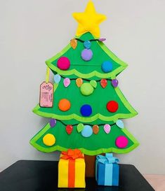 a paper christmas tree with presents under it