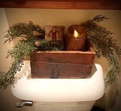 an old wooden box is sitting on top of a toilet with greenery around it