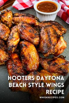 some chicken wings are sitting on a plate with dipping sauce in the background and text that reads, hooters daytona beach style wings recipe