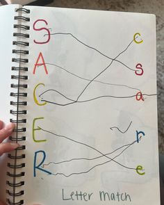 someone is holding up a spiral notebook with letters drawn on it and the words same color as each other