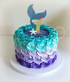 there is a cake decorated with purple, blue and green icing