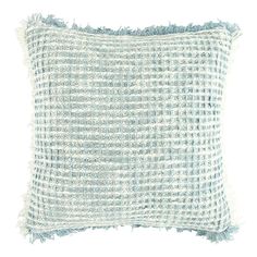 a light blue and white pillow with fringes on the front, sitting against a white background