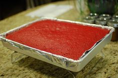 a red cake sitting on top of a metal pan