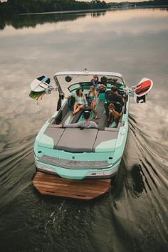 a group of people riding on the back of a boat in the water with two dogs