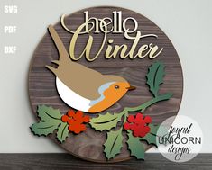 a wooden sign that says hello winter with a bird on it and holly leaves in the foreground