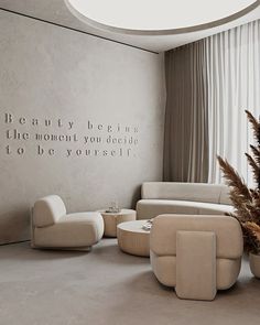 a living room filled with furniture and a quote on the wall