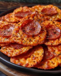 a black plate topped with pepperoni slices