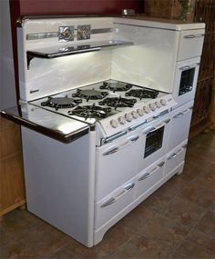 an old fashioned white stove and oven in a kitchen with tile flooring on the walls