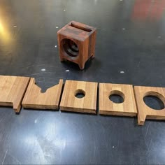 three pieces of wood sitting on top of a table next to a hole in the middle