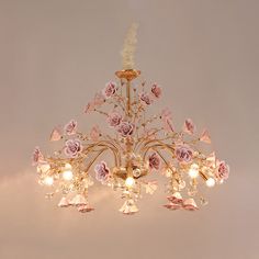 a chandelier with pink flowers hanging from the ceiling