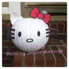 a hello kitty pumpkin sitting on top of a brick floor