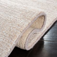 a close up view of the corner of a rug on top of a wooden floor