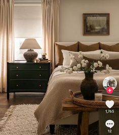 a bed room with a neatly made bed and two vases on the end tables