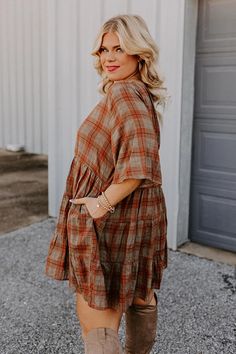 We have no doubt people will send compliments your way when you arrive in this darling plus size tunic dress featuring lightweight flowy material patterned with a rust and taupe hued plaid print, a rounded neckline, short sleeves, and a relaxed tiered skirt silhouette that falls into a straight mid-thigh length hemline! Measurements 1XL : Bust 44", Hip 48", Length 33.5", Sleeve Length 13.5", Waist 42". 2XL : Bust 46", Hip 50", Length 34", Sleeve Length 14", Waist 44". 3XL : Bust 48", Hip 52", Le Plus Size Dress With Leggings, Plus Size Fall Pictures, Mid Size Fall Fashion, Plus Size Overall Dress, Plus Size Fashion For Women With Belly, Western Fall Outfits, Curvy Boho, Plaid Tunic Dress, Plus Size Tunic Dress