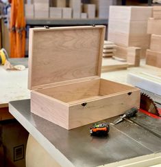 a wooden box sitting on top of a table next to a pair of pliers