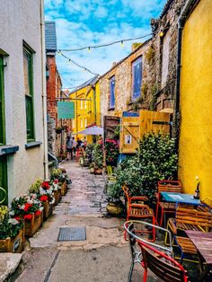 an alley way with tables and chairs lined up along the side of each other on both sides