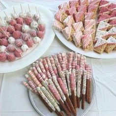 desserts and sweets displayed on plates at a party or wedding reception in pink and white