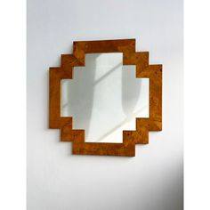 a mirror that is on the wall in front of a white wall with a shadow