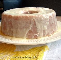 a bundt cake sitting on top of a white plate next to a yellow towel