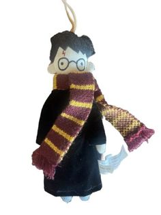 a harry potter ornament hanging from a string on a white background with a black shirt and purple scarf