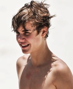 a close up of a person with no shirt on and hair blowing in the wind