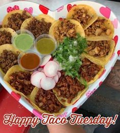 a heart shaped plate filled with tacos and sauces