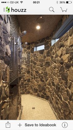 a bathroom with stone walls and flooring next to a shower head mounted faucet